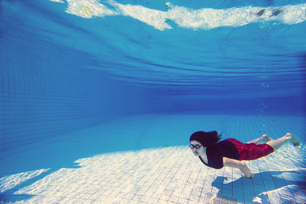 Asian young woman in business clothes and glasses  under water