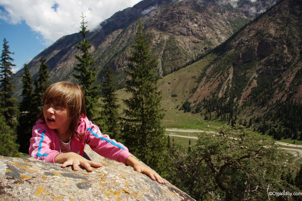 A little girl surrounded by Kyrgystan gorges, Issyk-Kul